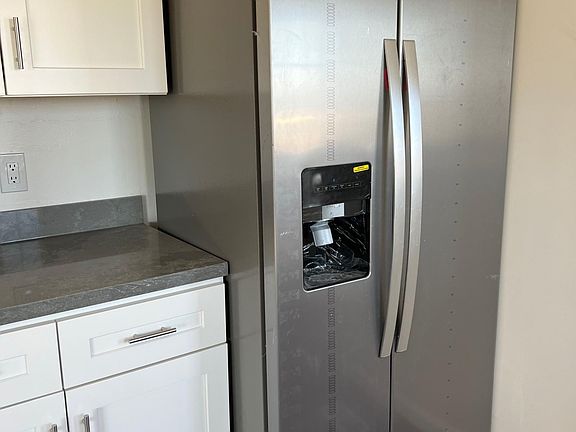 New refrigerator with ice machine, kitchen counters and cabinets