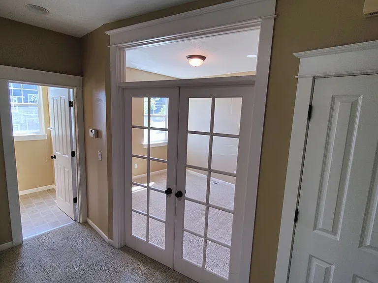 Entrance to Den/Office Space, transom window above doors and entrance to half bathroom. The door to the pantry off the kitchen.