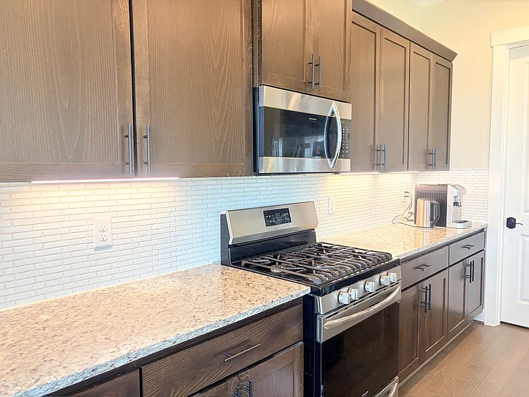 Modern kitchen with granite countertops and stainless steel appliances.