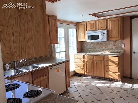 Kitchen with oak cabinets and atrium door opening to the back patio.
