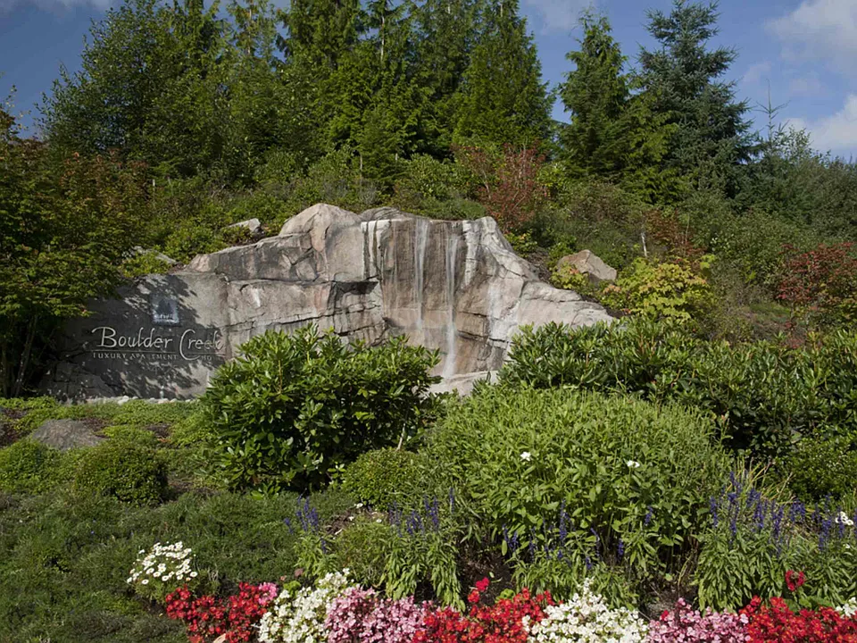 A landscaped water feature creates a welcoming focal point among the evergreens.