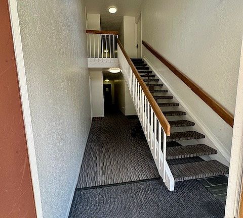 Walking in the building- door is on the right under the stairs