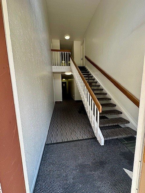 Walking in the building- door is on the right under the stairs