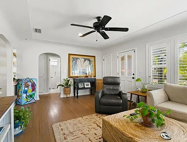 Living room with furniture (archival photo) showing main front door and arched entrance leading to bathroom and bedrooms