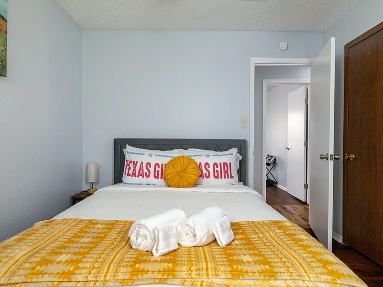 Queen bed with vibrant yellow accents and Texas-inspired decor.