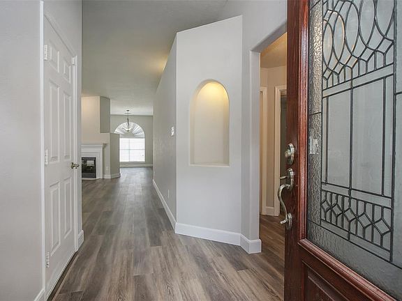Come inside and take a look at the freshly updated interior! Right away, you notice modern laminate flooring that flows throughout the home. And, there are interesting architectural details like this illuminated art niche and the illuminated faux stu