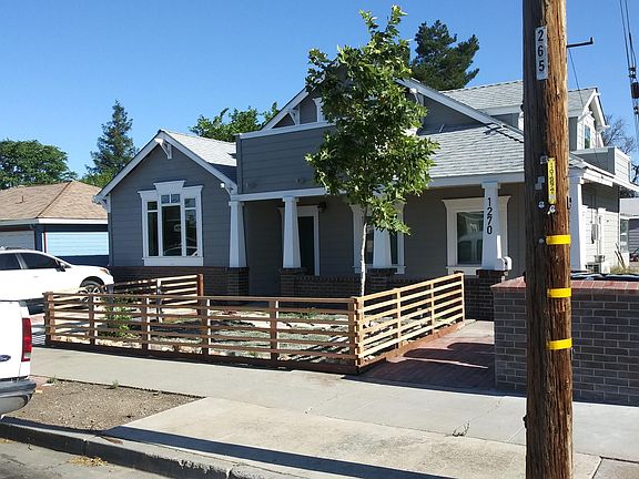 Fenced front yard. The side driveway to the back is just out of view to the right of the picture.