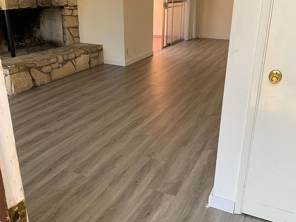 living room with new wood laminate floors, fireplace and patio sliding door
