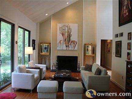 The living room boasts cathedral ceiling and large glass doors