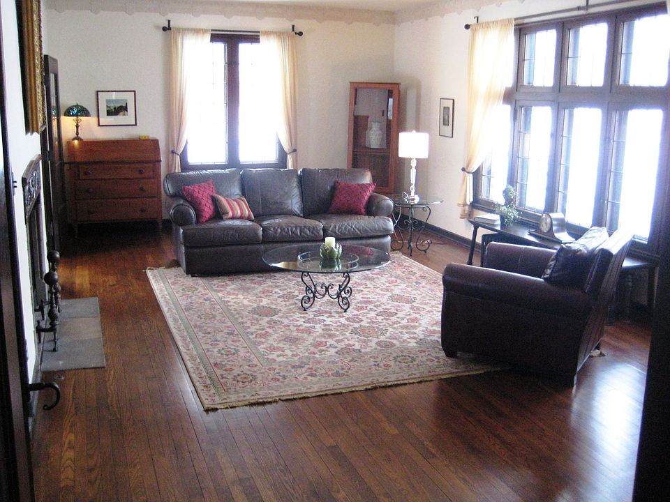 SUN~FILLED STEP DOWN LIV RM W/TALL LEADED GLASS WINDOWS & HAND CARVED FIREPLAC