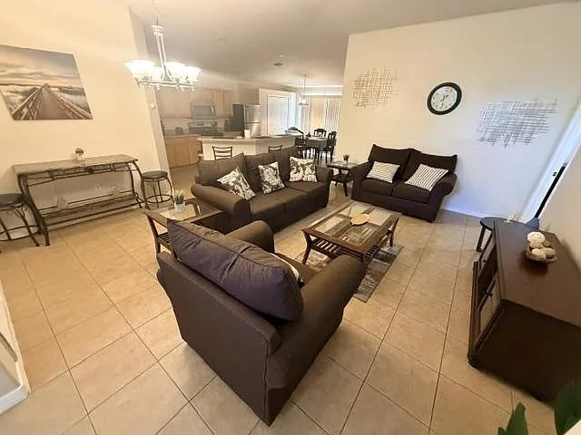 Open-concept living area with ample seating, tile floors, and a clear flow into the dining space and kitchen.