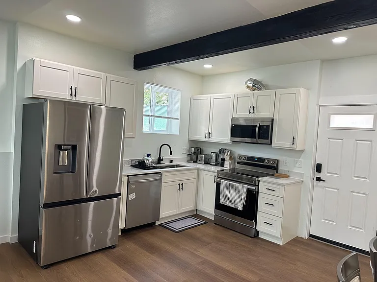 Updated kitchen with shaker cabinets, stainless appliances, and ample counter space plus a window over the sink.