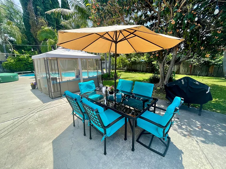 Backyard with a large patio set and propane grill
