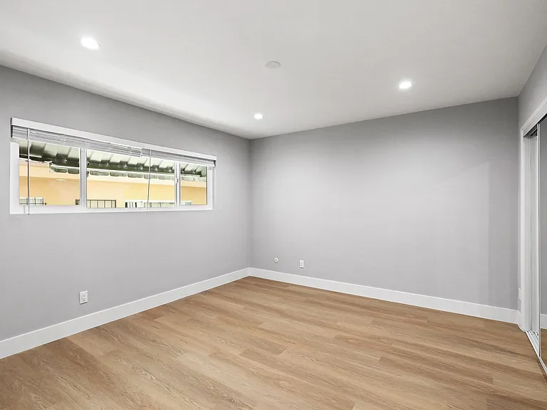 Bedroom with Mirrored Closet, Vinyl Flooring, Window, and Recessed Lighting