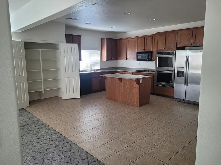 Kitchen view from Dining room - pantry doors are open.