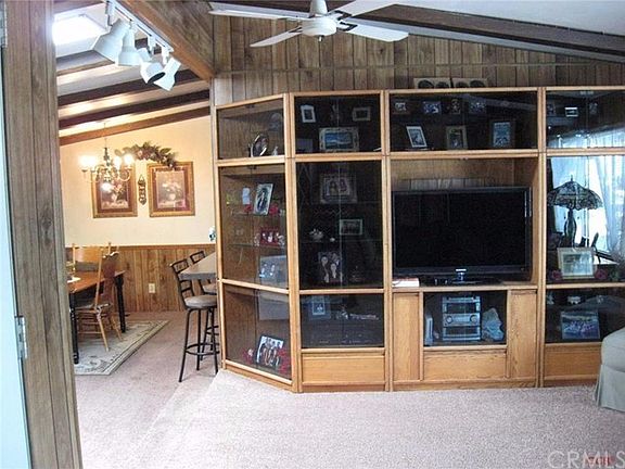 Open living and dining area, skylight, ceiling fan and fireplace.