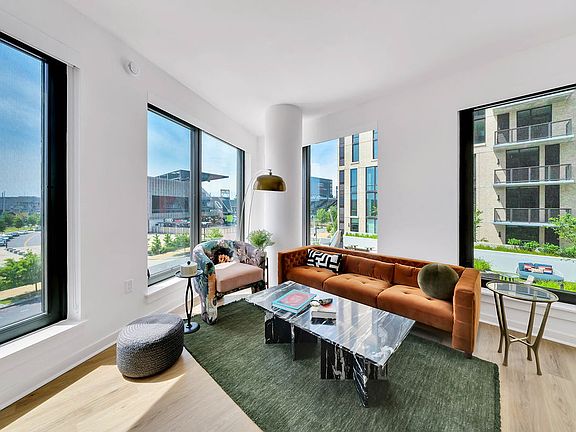 Open-concept living room with spacious size and large windows.