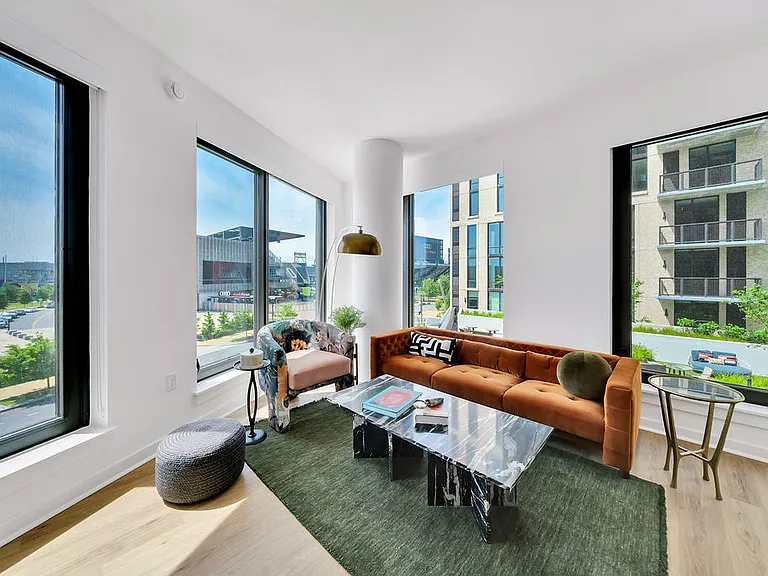 Open-concept living room with spacious size and large windows.