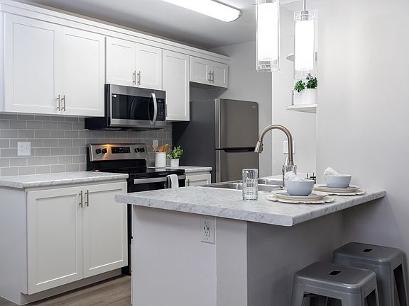 Bright kitchens adorned with gleaming stainless-steel appliances and marble-like countertops.