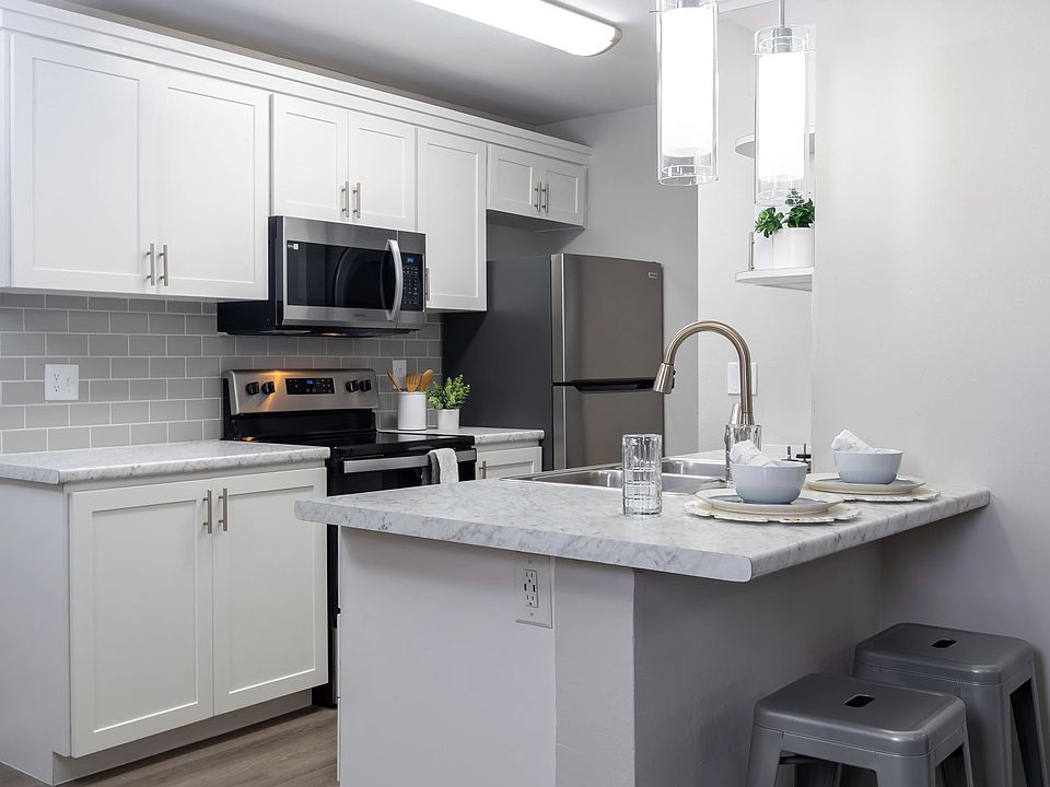 Bright kitchens adorned with gleaming stainless-steel appliances and marble-like countertops.