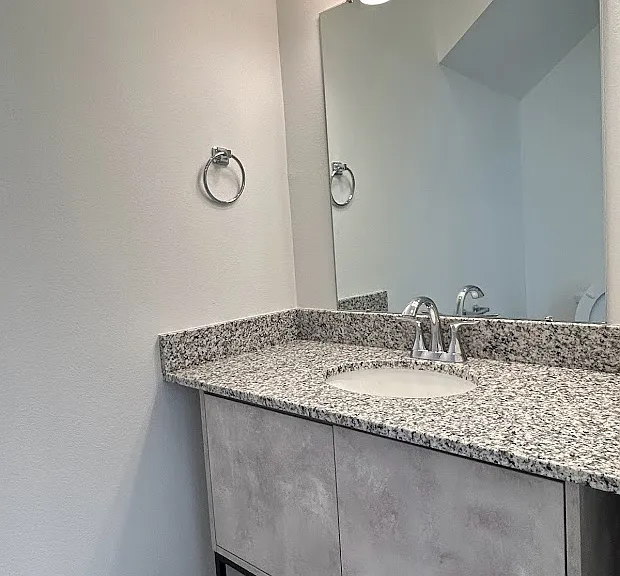 1/2 bath located just off living & kitchen area has a granite countertop.