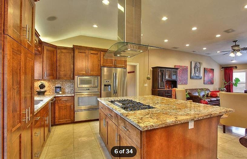 Kitchen with built in 6 burner gas stove and granite island - storage cabinets under