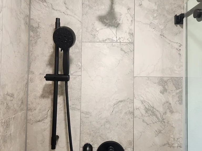 Primary bathroom shower fixtures feature adjustable/detachable shower head.