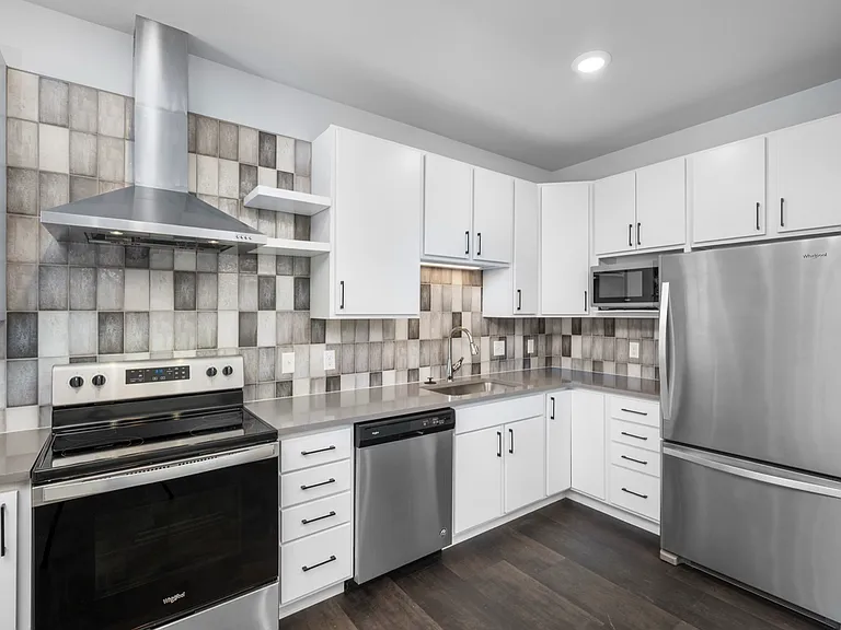 Modern kitchen with sleek stainless steel appliances, chic tile backsplash, and ample white cabinetry. Modern kitchen with sleek stainless steel appliances, chic tile backsplash, and ample white cabinetry.