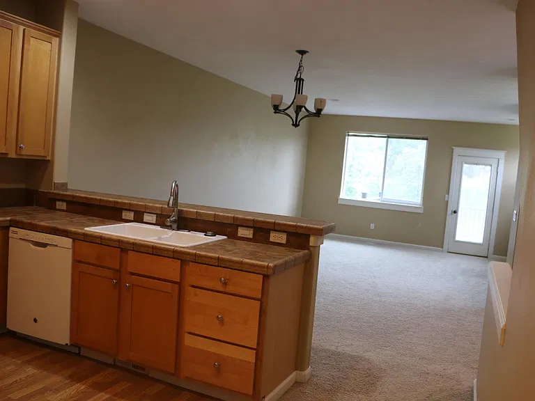 Shows part of the Kitchen and Dining/Living room, large window to the backyard and the door to the deck.