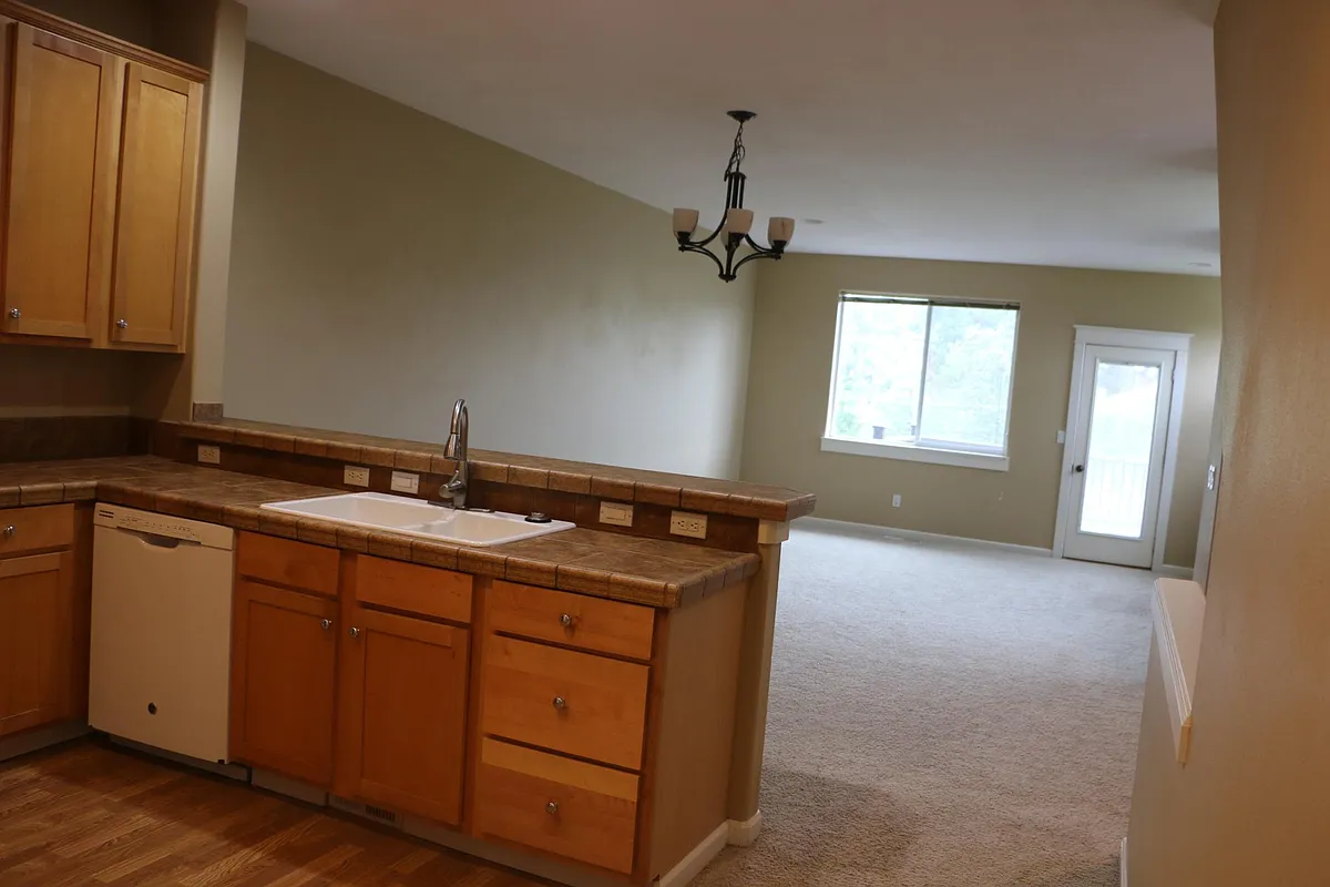 Shows part of the Kitchen and Dining/Living room, large window to the backyard and the door to the deck. - 20799 Viewpoint Rd