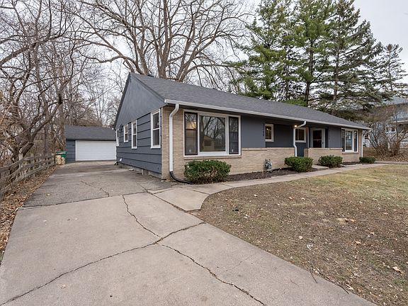 Front of 3260 France Ave North with view of driveway and 2 car garage in the back.