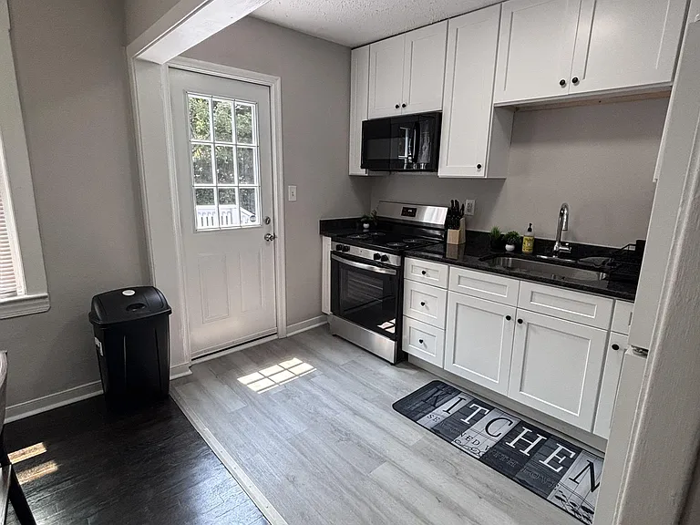 Efficient kitchen with shaker cabinetry, ample counter space, and stainless range with microwave, plus a door to the outdoors