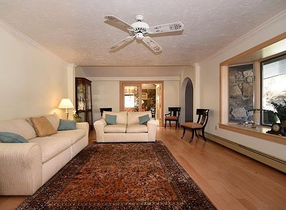 The spacious living room with hardwood floors and large bay window.