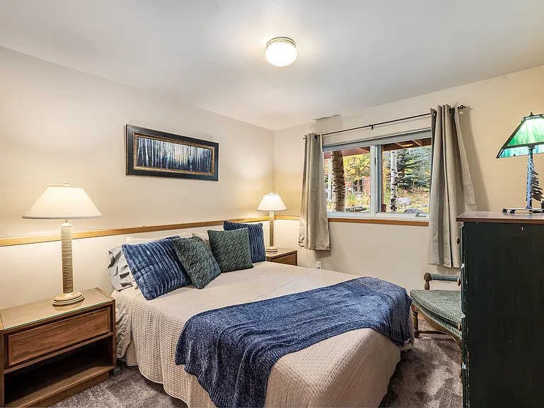 Lower level bedroom with queen size bed - looks out to backyard and waterfall