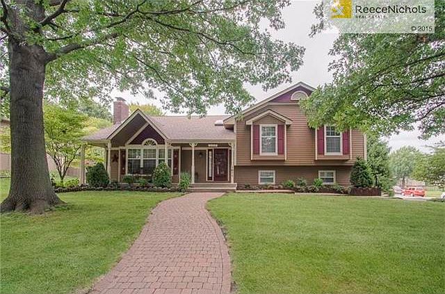 Home sits on a corner lot with a beautifully manicured lawn and mature trees.