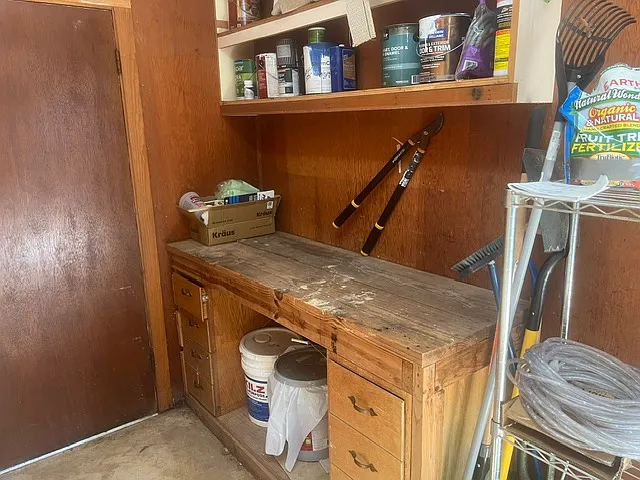 build in work bench with selves in the garage. Door to the left leads to back yard access.