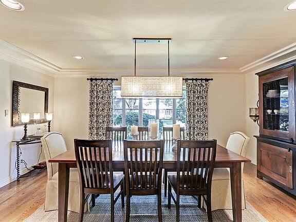 Custom ceiling detail, hardwood floors, and dramatic view to front yard through bay window.
