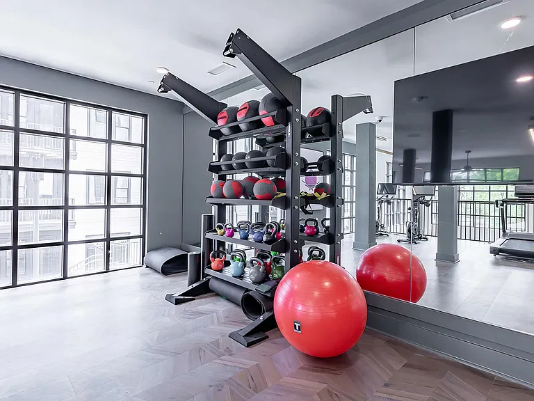 Spacious free-weight area with kettlebells, exercise balls, and floor mats