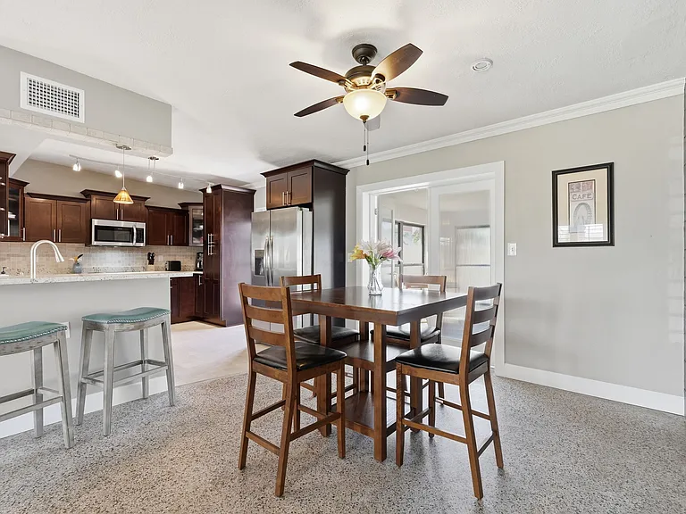 Wrap around high counter with bar stools with open kitchen and dining table.