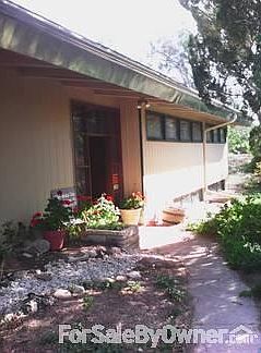 Landscaped walkway to front door behind foliage offer privacy.
