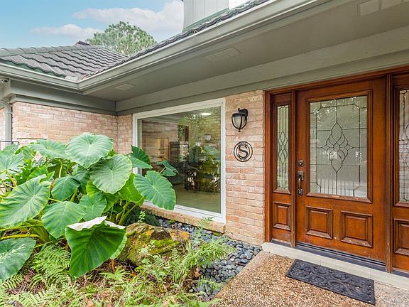 This home sits on a beautiful lot with mature trees and beautifully kept landscaping. The solid wood door and side panels with decorative leaded glass make a handsome statement.