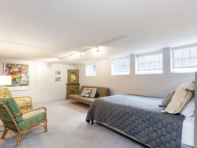 The third bedroom is on the garden level, with ample sunlight and a cozy queen bed and large rec room