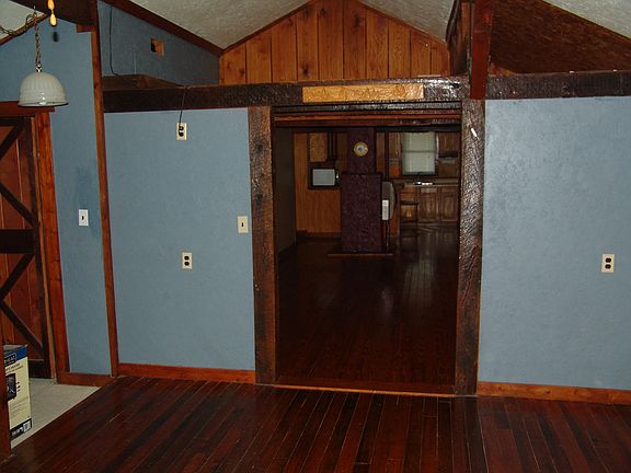 Sleeping area looking into living area with storage loft abo