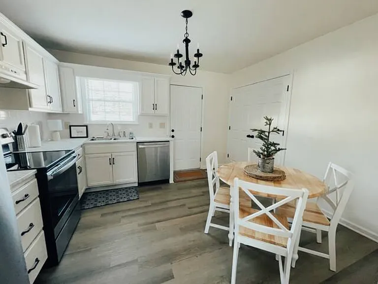 Kitchen with dining area. Refrigerator, stove, dishwasher, and countertop microwave included. Included washer and dryer behind doors on the right.
