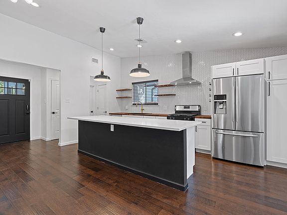Kitchen. Deep single basin sink. Butcher block counter tops. Granite countertops. 12-footisland. Modern finishes.