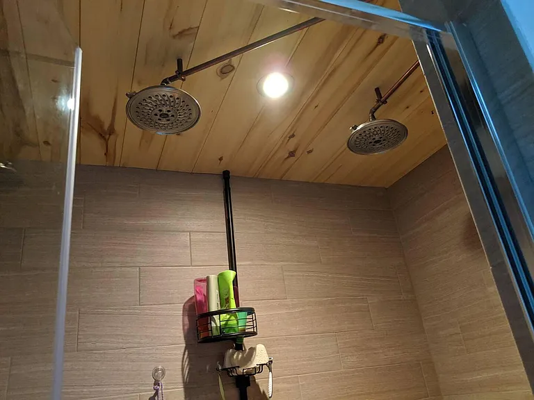 Upstairs shared bathroom with double sinks, walk-in shower with dual heads