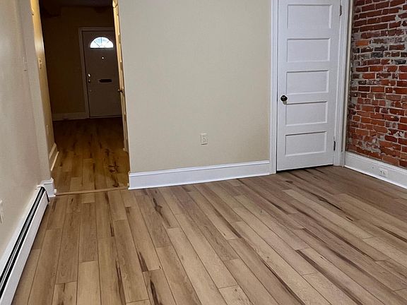 View from kitchen of dining room and hall to the front door. Bedroom to the left of the hall. Two closets to the right in the hall.