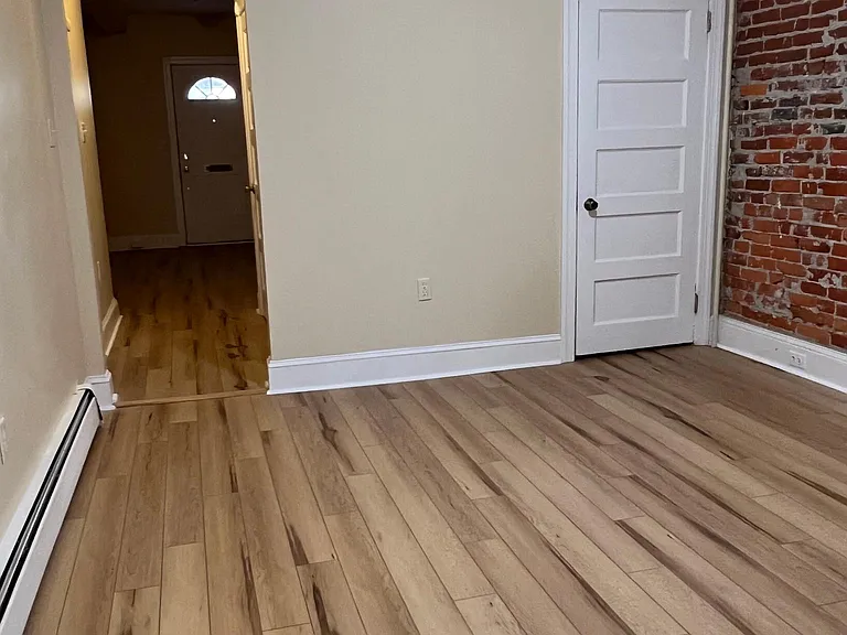 View from kitchen of dining room and hall to the front door. Bedroom to the left of the hall. Two closets to the right in the hall.
