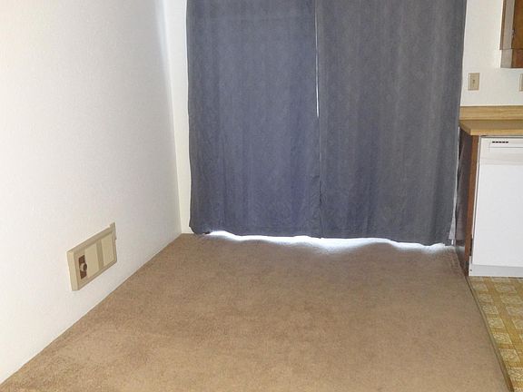 Dining room (view from the living room). Behind the curtains is the front private patio through the sliding patio door).
