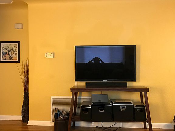 Cheery yellow paint color in living area. Flat screen TV mount will be ready for you to just hang your TV.